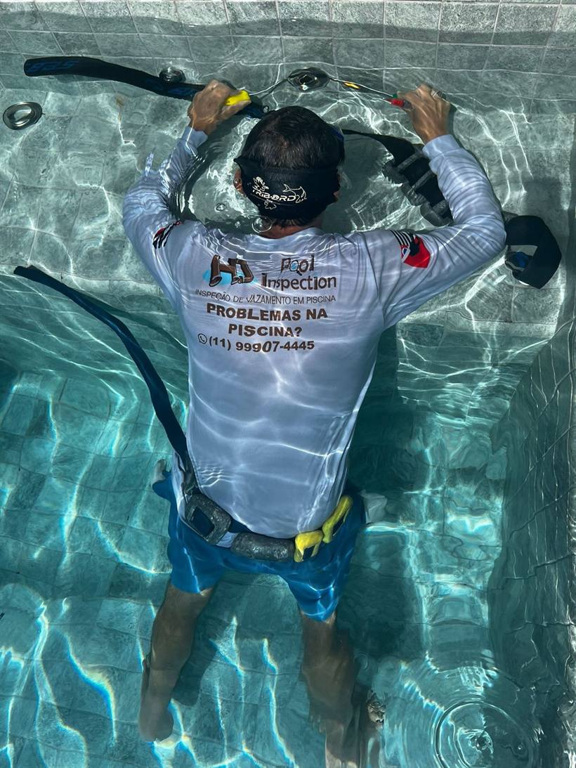 Técnico da HD Pool Inspection dentro da piscina com cinto de lastro e equipamento de mergulho
