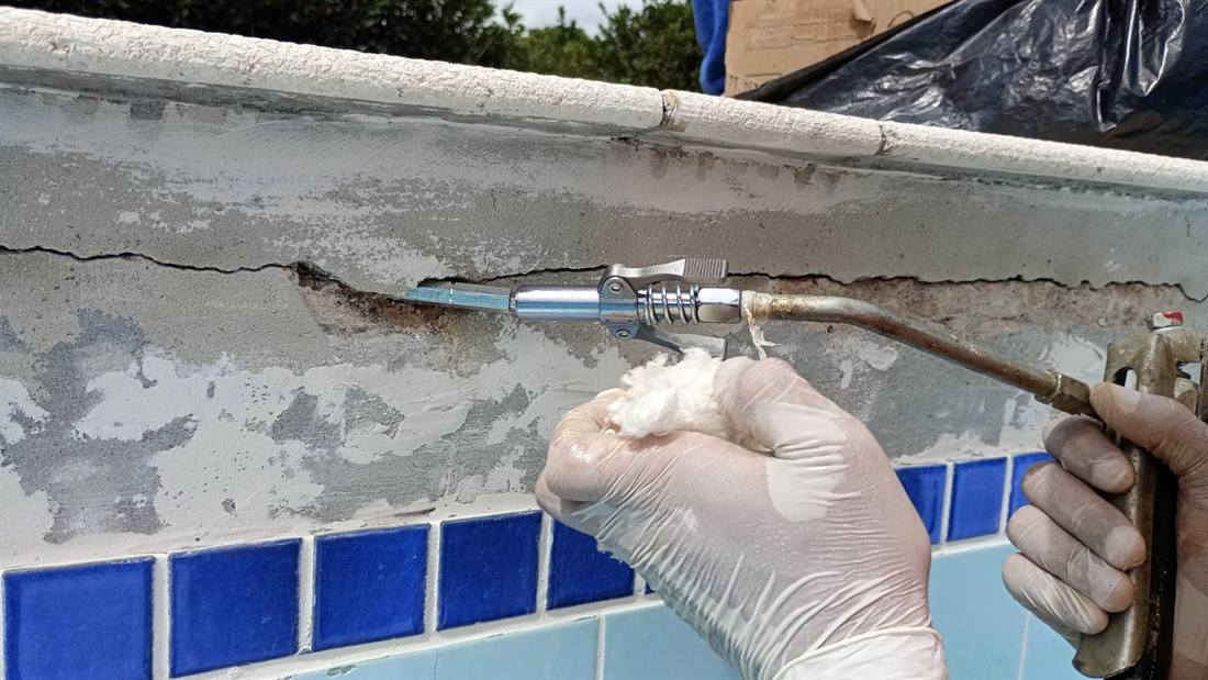 Trinca localizada na borda da piscina recebendo tratamento com aplicador